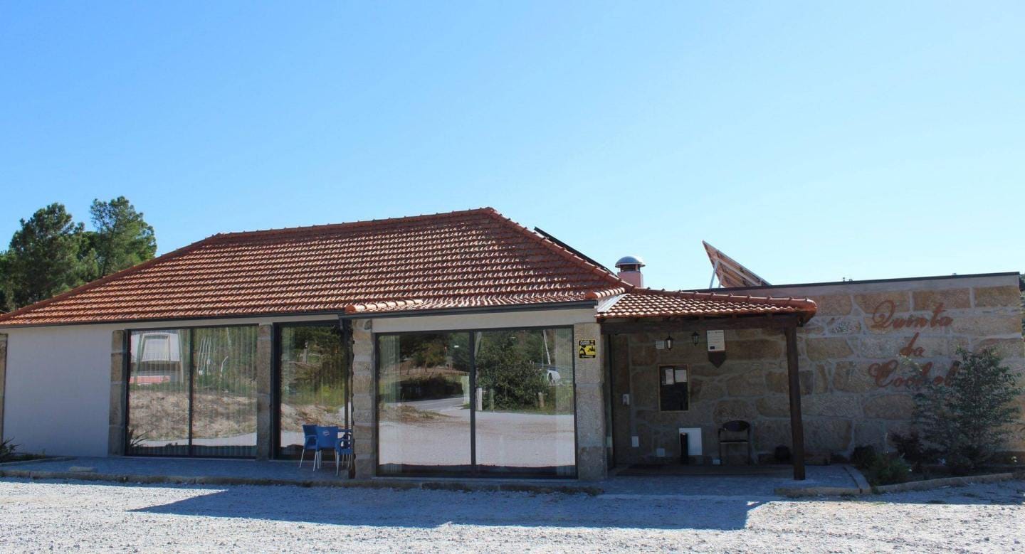 Fachada de restaurante com telhas vermelhas, grandes janelas e zona de esplanada coberta