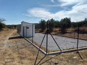 Estação de tratamento de águas residuais modular com vedação metálica em zona rural.