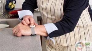 Homem a interagir com smartwatch no pulso, num interior residencial.
