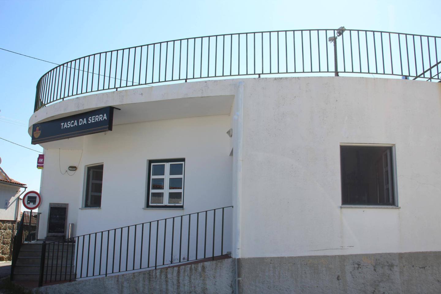 Edifício branco da estação Tasca da Serra com varanda metálica e sinalética.