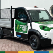Camião elétrico branco e verde para recolha de biorresíduos com caixa basculante aberta